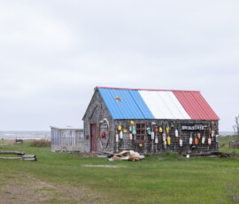 Cabane de pêcheur couverte de bouées, toit aux couleurs acadiennes, Nouveau-Brunswick