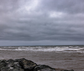 Mer agitée et rochers sous un ciel d'orage, côte du Nouveau-Brunswick