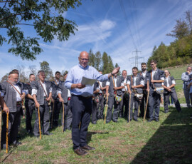 Présentation de Patrice Borcard devant les chanteurs alignés sous les arbres au Chalet de Bataille