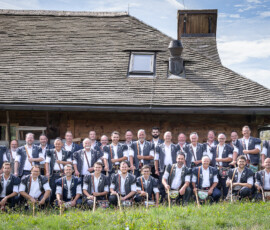 Photo de groupe du Chœur des Armaillis de la Gruyère devant le Chalet de Bataille